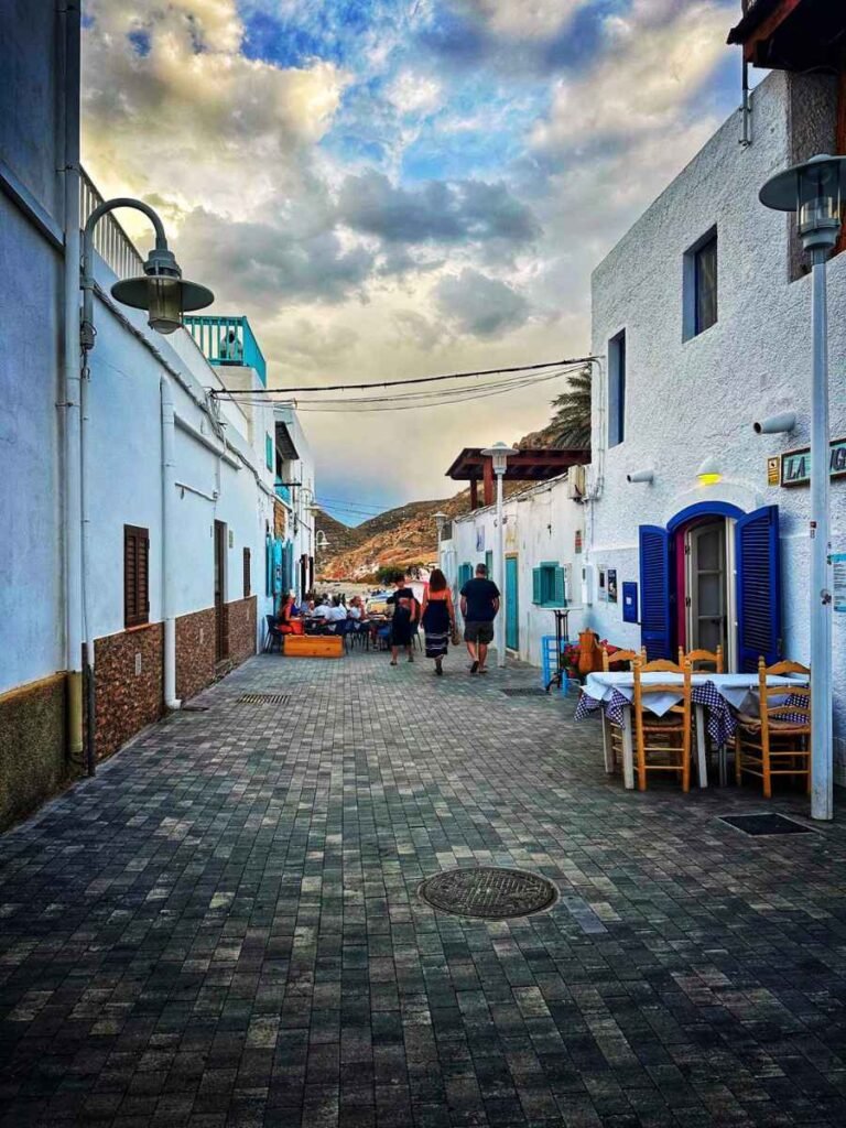 Calle blanca de Las Negras con terrazas al atardecer