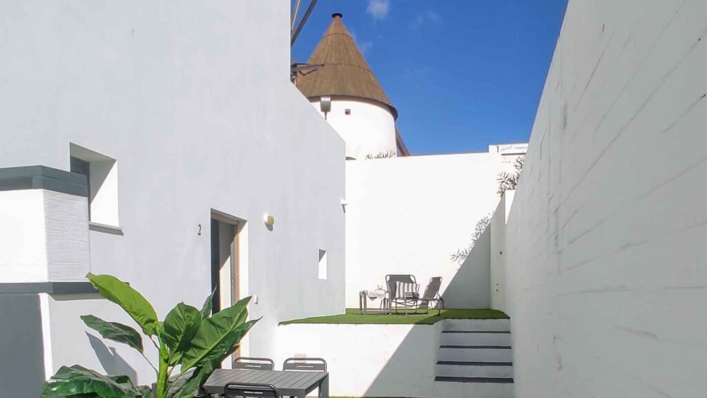 Patio blanco con el molino de Las Negras al fondo