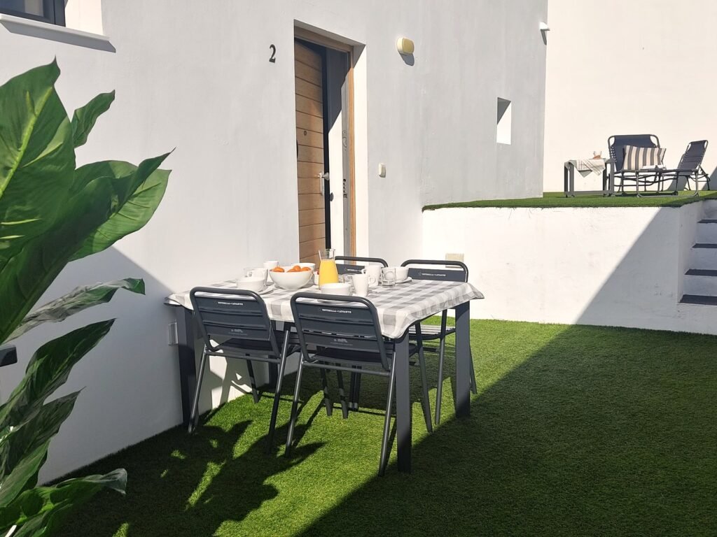 Patio con césped y mesa de un apartamento de dos dormitorios