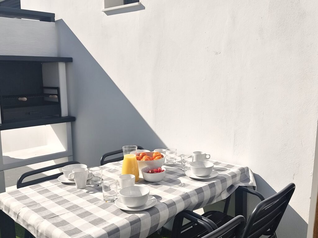 Barbacoa de obra y mesa con desayuno en la terraza